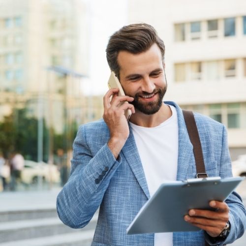 uomo che parla al telefono guardando un tablet