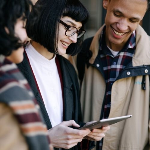 persone che guardano sorridenti un tablet